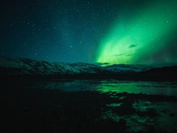 Scenic view of snowcapped mountains against sky at night