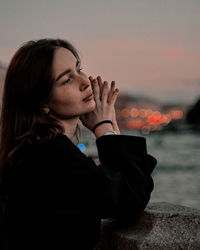 Portrait of young woman with arms raised