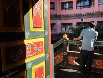 Rear view of man standing against building