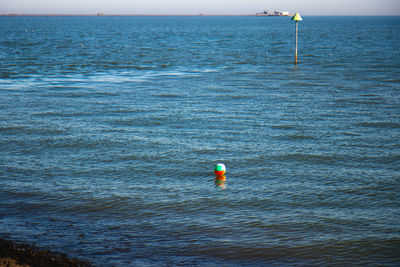 Person paragliding in sea against sky