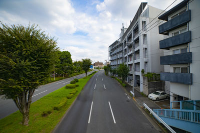 Road amidst buildings against sky