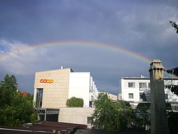Low angle view of rainbow over buildings in city