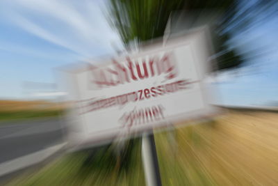 Blurred motion of car on field against sky