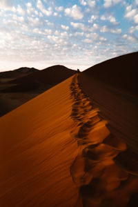 Sand dunes in desert against sky