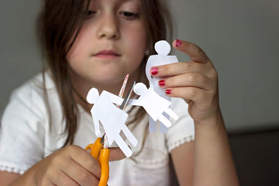 Close-up of girl holding paper chain at home