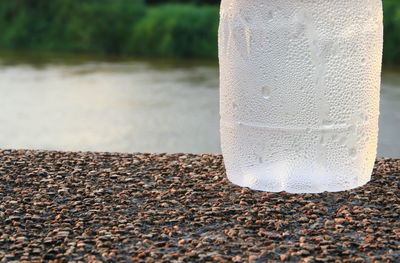 Close-up of wet glass on beach