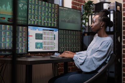 Young businesswoman analyzing graph on computer