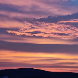 Scenic view of dramatic sky over silhouette landscape