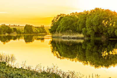 Scenic view of lake against sky at sunset