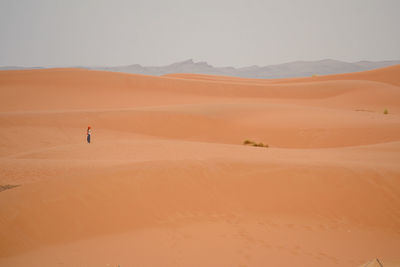 Man standing on desert against sky