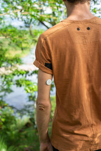 Rear view of man standing against plants