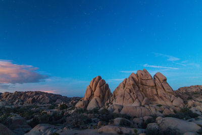Rock formations in desert against blue sky