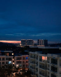 Buildings against blue sky at night