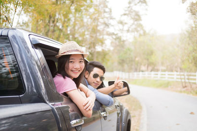 Portrait of smiling friends traveling in car