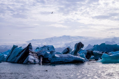 Icebergs in sea against sky during winter