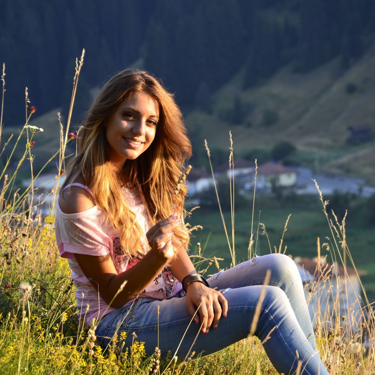 young adult, young women, leisure activity, lifestyles, person, casual clothing, long hair, three quarter length, sitting, smiling, focus on foreground, waist up, happiness, grass, portrait, looking at camera, side view