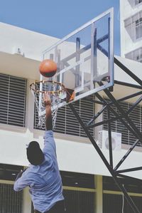 Man playing with basketball hoop