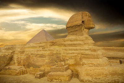 The great sphinx of giza against cloudy sunset sky