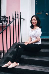 Portrait of smiling woman sitting on staircase