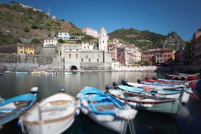 Boats moored in river against buildings in city