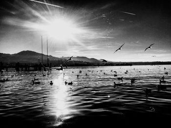 Sun shining through clouds over sea