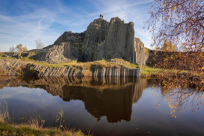 Scenic view of panska skala - basalt rock columns. two people standing on top of the rock formation