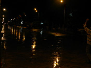 Reflection of illuminated street light in water at night