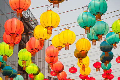 Low angle view of lanterns hanging against sky