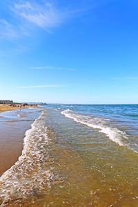 Scenic view of beach against blue sky