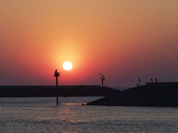 Scenic view of sea against orange sky