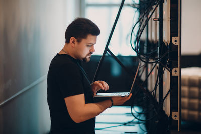 Side view of young man using mobile phone