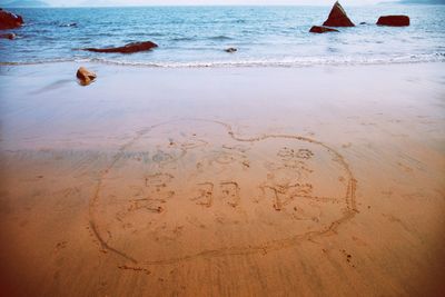 Drawing on wet sand at sea shore