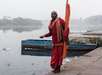 Full length of man standing on shore against sky