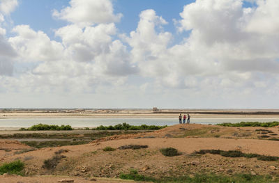 People on beach against sky