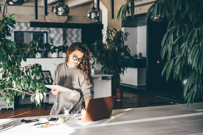 Freelancer woman using laptop at comfortable office, green co-working modern workplace