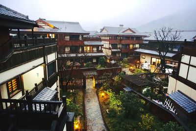 High angle view of buildings by street against sky