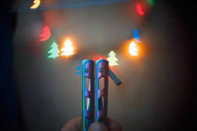 Close-up of hand holding lit candles
