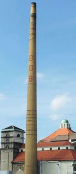 Low angle view of factory against blue sky