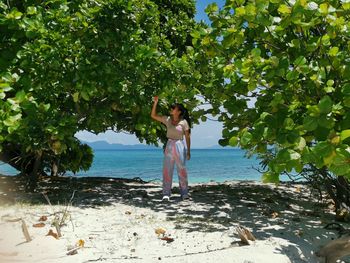 Rear view of woman standing at beach