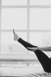 Low section of woman exercising by window