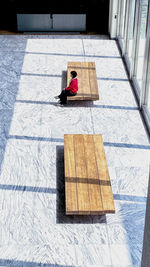 High angle view of girl sitting on wooden floor