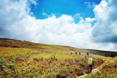 Scenic view of grassy field against cloudy sky