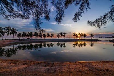 Scenic view of lake against sky at sunset