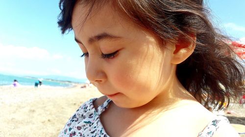 Close-up of cute girl at beach on sunny day