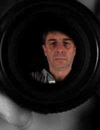 Portrait of mature man reflecting on camera lens