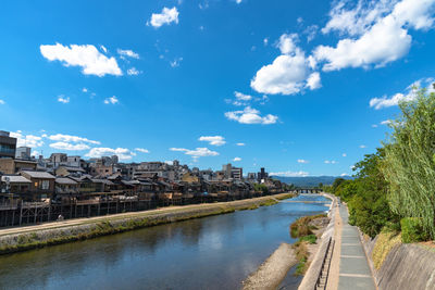 River amidst buildings in city against sky