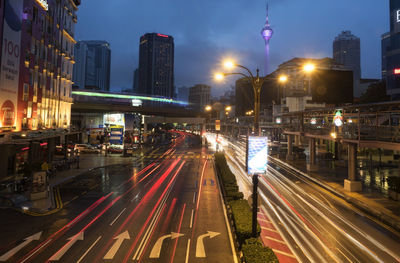 Light trails on city street against sky at dusk