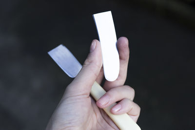 Close-up of person holding hands against gray background