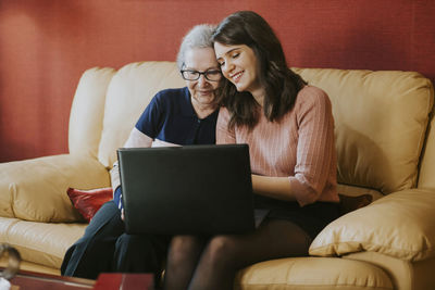 Granddaughter showing her grandmother something on the laptop