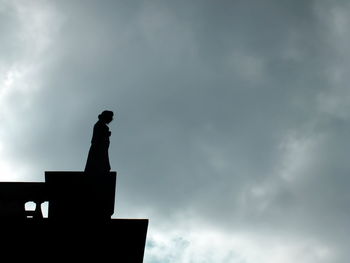 Low angle view of silhouette statue against sky